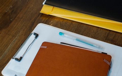 桌上的空白文件夹、记录本和笔，作为留学学历认证材料准备示意图